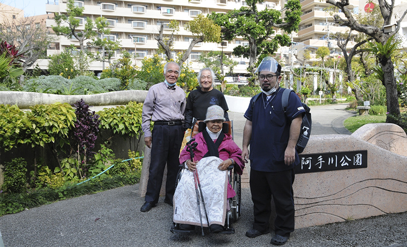 後列左から筆者、公園の手入れをする砂川さん、前列左はマンション経営者の金城由紀子さん、同右は金城さんのヘルパーさん
