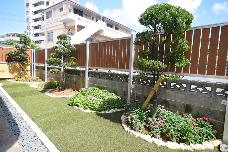 和風庭園｜人工芝で手入れが不要な芝庭。琉球石灰岩で縁取られた部分には妻の好きだった花々を植えた