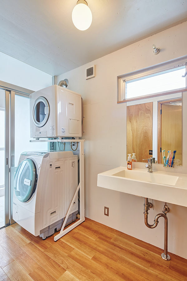 ロカルウ,洗面脱衣室は室内物干し場も兼ねる。写真背後に収納棚があり、ガス乾燥機で乾かした衣類を収める