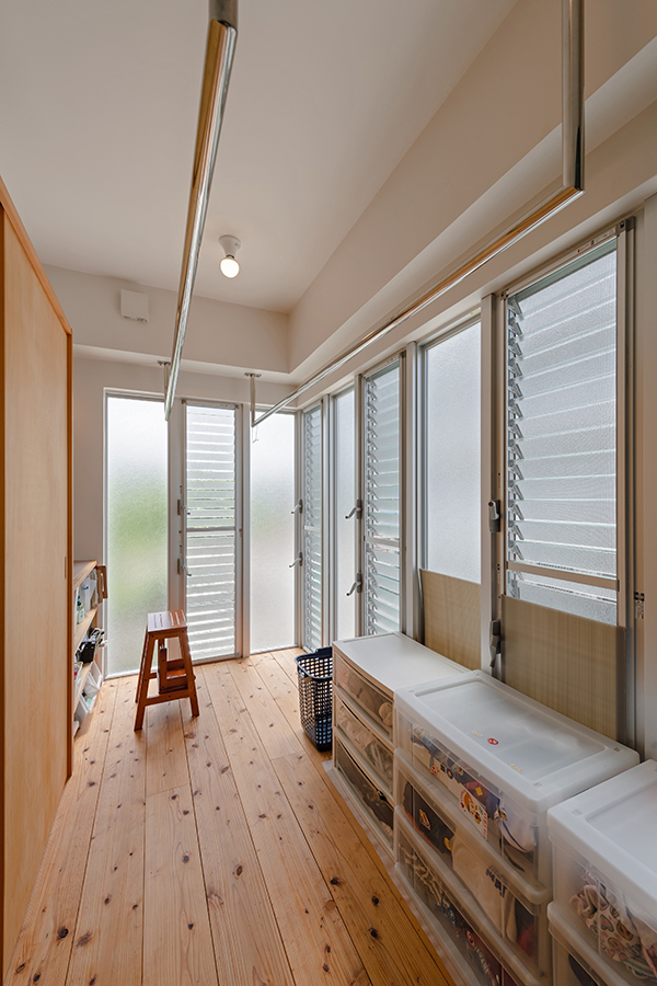 ２階キッチンの裏手にある室内物干し場。南側にあって暖まりやすい。ジャロジー窓を多用して風通ししやすく、曇りガラスでアパートからの視線を遮る