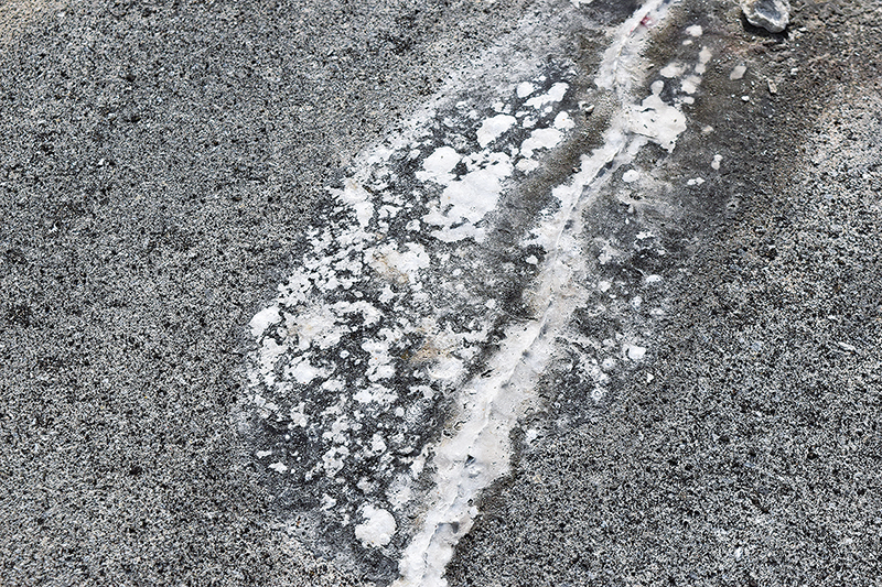 コンクリートの石灰成分が流れ出して白く固まった「遊離石灰」。ひび割れが生じていて塩害などの可能性を示唆する