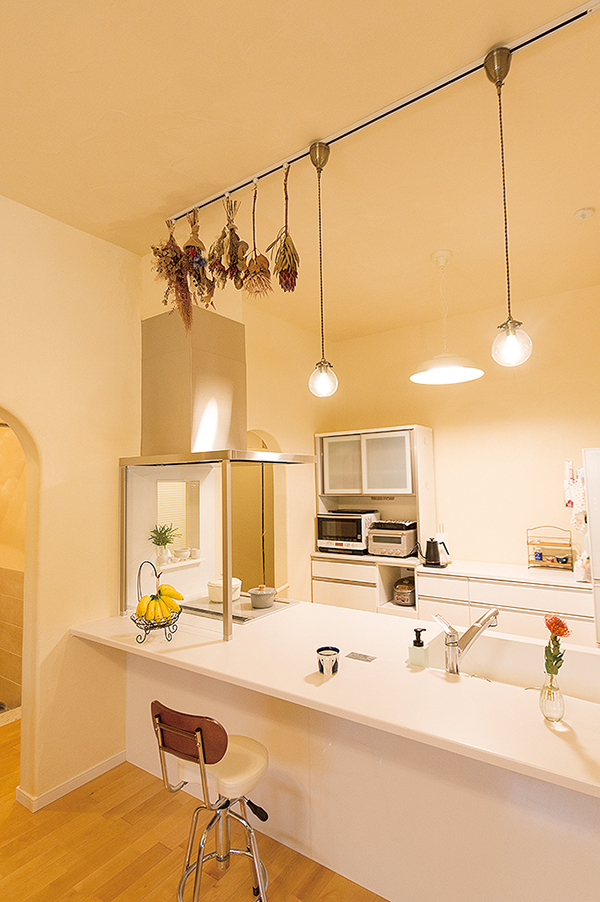 キッチン上部は、キッチンの幅に合わせてライティングレールが埋め込まれているから、照明の位置も個数も変えやすい。照明だけでなく、ドライフラワーもつり下げて空間の彩りに