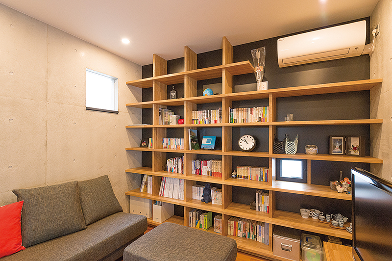 リビングの壁一面に造り付けた本棚は、棚の奥行きが３５㌢あるため本だけでなくいろいろな物が収納できる