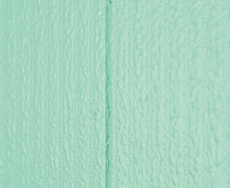 ２階リビング。エメラルドグリーンの広い壁が目を引く。よく見ると壁や天井には凹凸の模様がある（下写真）