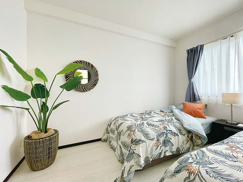 after　寝室。Mさんセレクトのリゾート感あふれるベッドカバーに合わせて、ミラーと観葉植物など全体をステージング