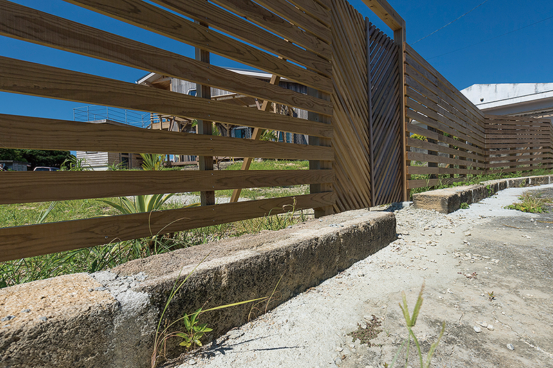 道路との境界線にも粟石を使った。木製のフェンスは新垣さんらが手作りしたもの