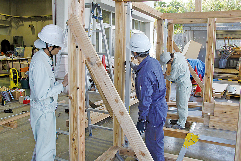沖縄職業能力開発大学校での木造軸組構法の施工実習の様子。部材は学生が墨付けを行い、のこぎりやのみなどの手工具、角ノミ機などの電動工具で加工した
