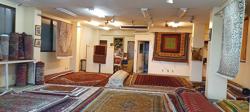 ワンルームの空間に大小さまざまな絨毯が所狭しと広げられている