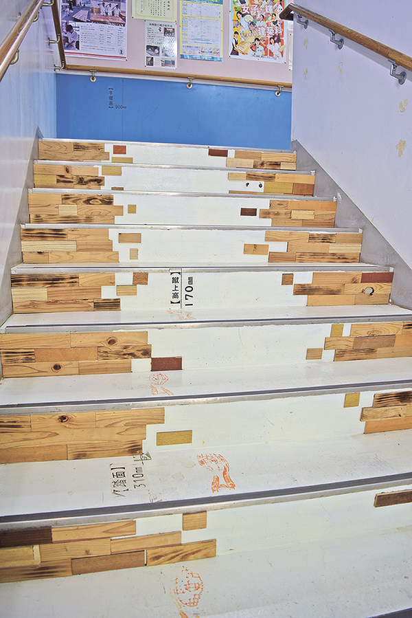 建築科棟の階段。木材が貼られているほか、踏面（ふみづら）の幅や蹴上（けあげ）の高さなどの寸法も書かれている