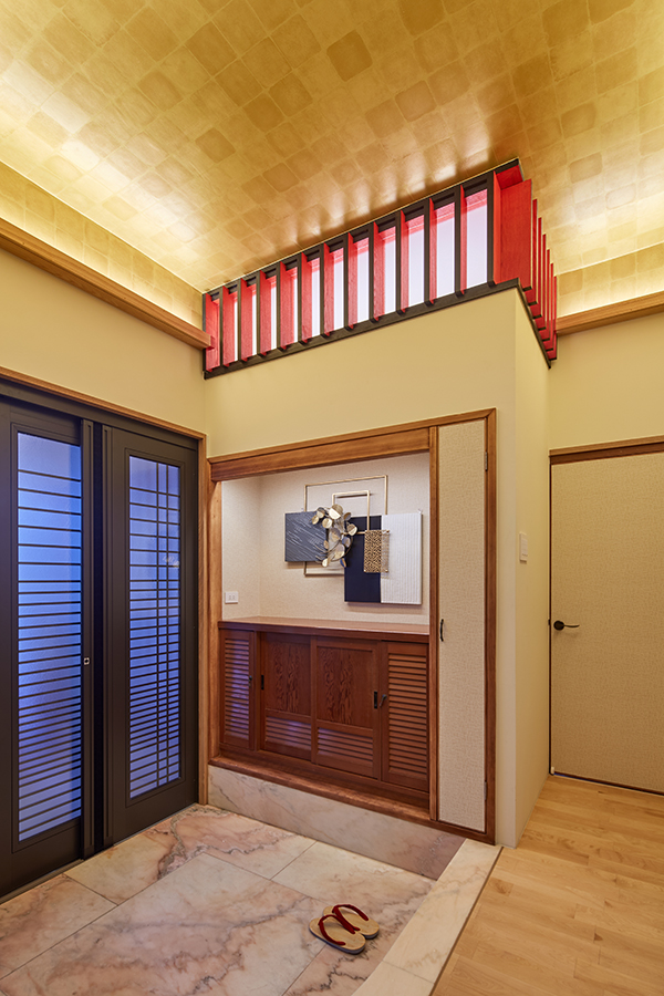 玄関。金色の天井に赤と黒の格子が映え、和モダンな印象