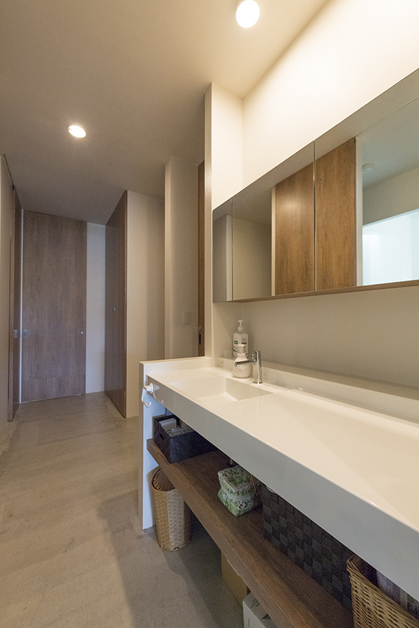 シンプルなデザインで、広々とした洗面台。ＬＤＫから個室へ向かう廊下に設けられていて、正面に浴室がある