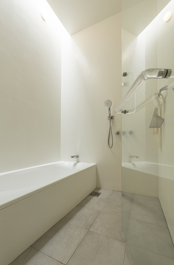 浴室は縁なしのガラス扉で、取っ手も透明に。壁は左官仕上げで、表面を塗装した。枠がないため汚れにくく、掃除がラクにできる